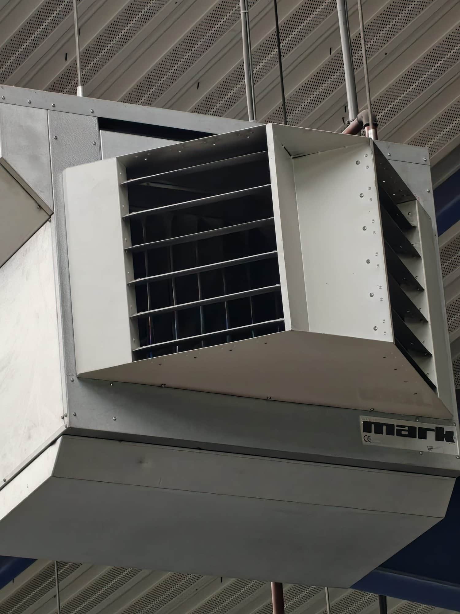 Plafondhangende luchtverwarmer in een werkplaats.