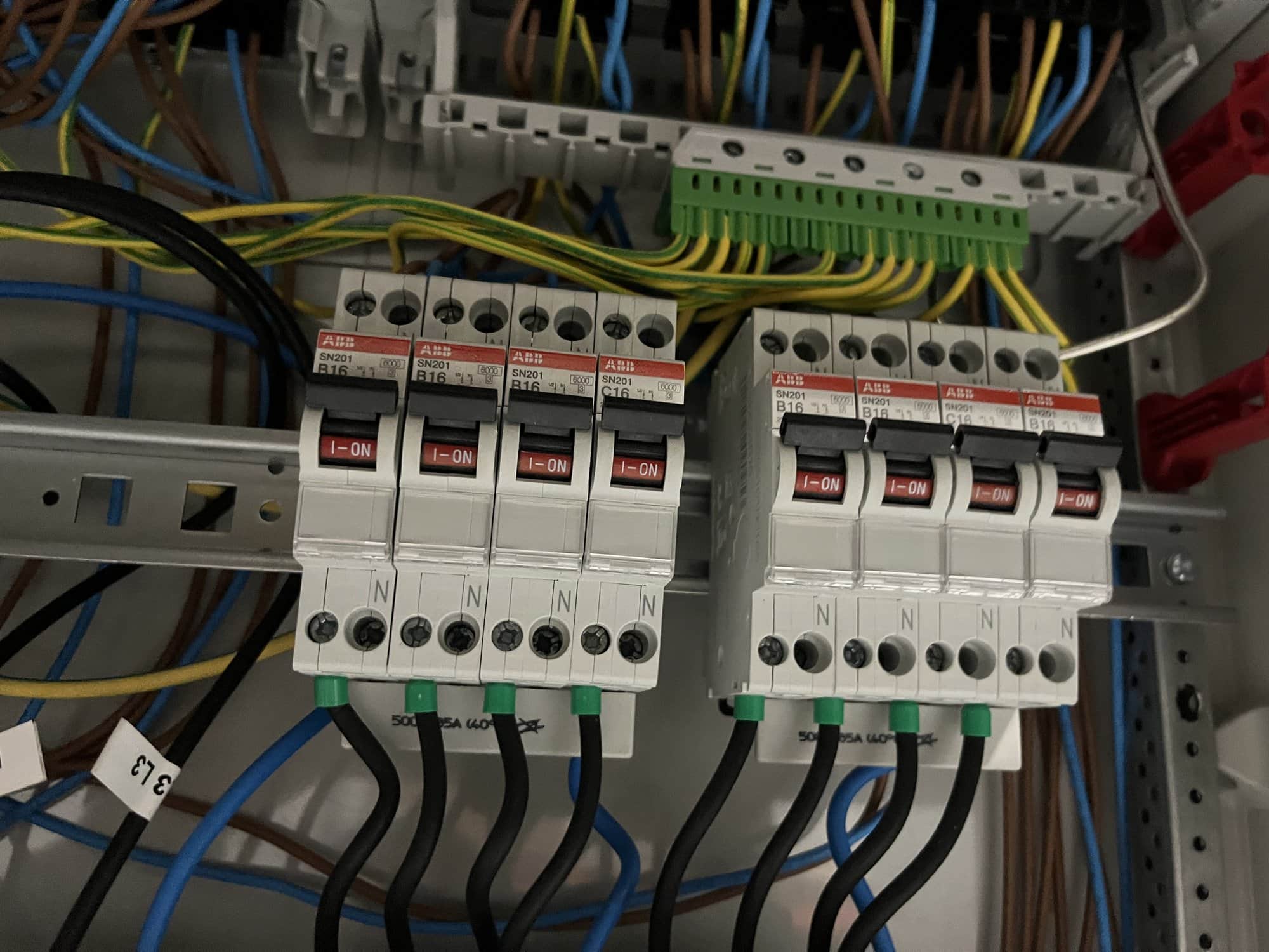 Close-up van installatieautomaten met strak gelegde aders en klemmenstrook.