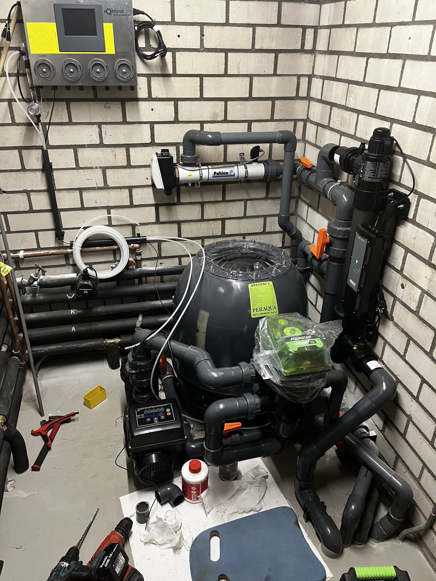 Technische ruimte met zwembadfilter, pomp en doseerapparatuur tijdens de installatie.